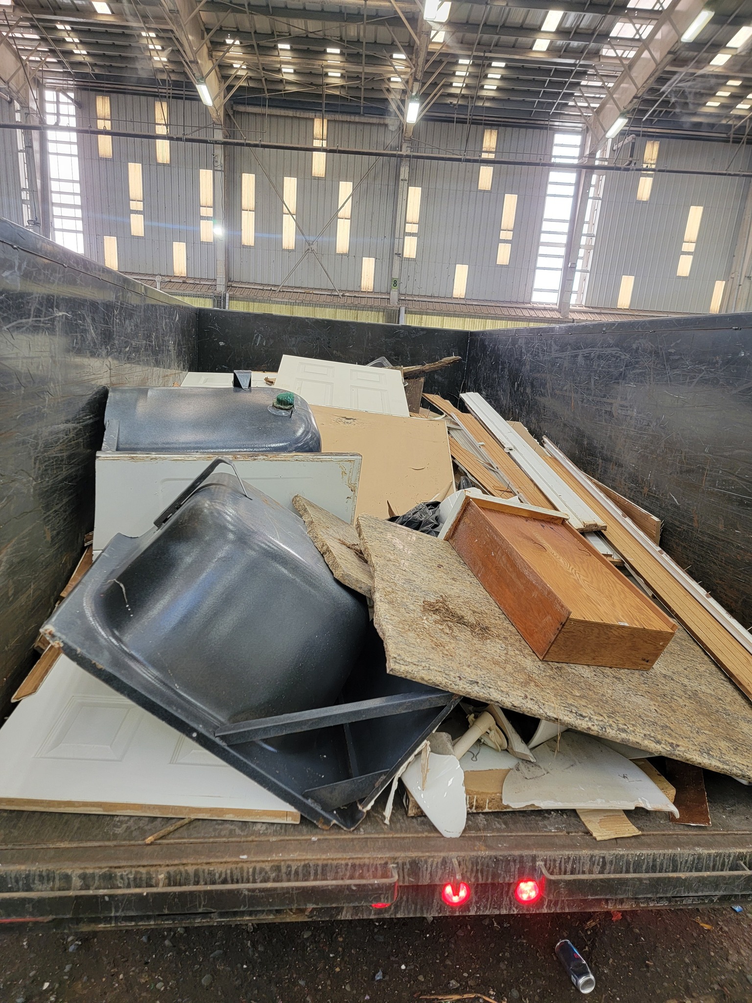 Drywall, tile, and construction debris pile ready for renovation cleanup in Auburn
